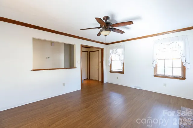 a view of a big room with wooden floor and windows