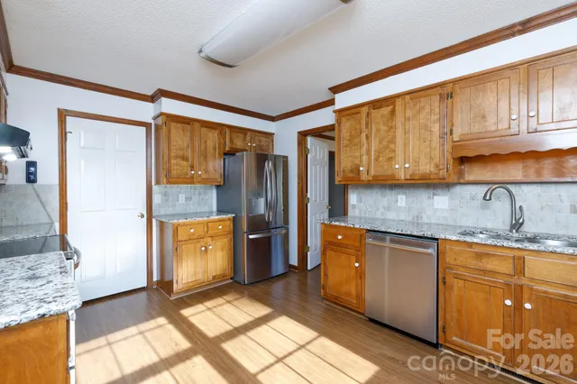 a kitchen with stainless steel appliances granite countertop a refrigerator and a stove