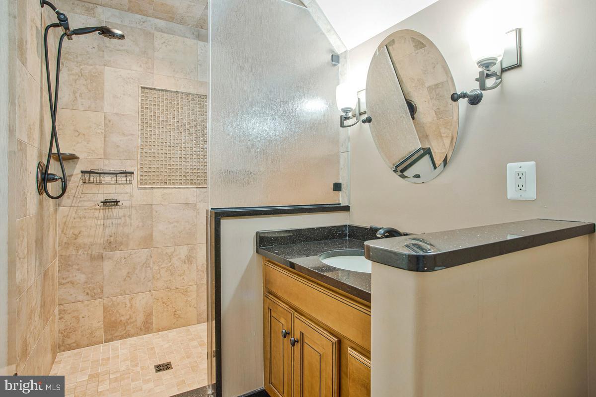 5 Jessie Road Harwood, MD 20776 - Photo 55 of 87 a bathroom with a granite countertop shower a mirror and a sink