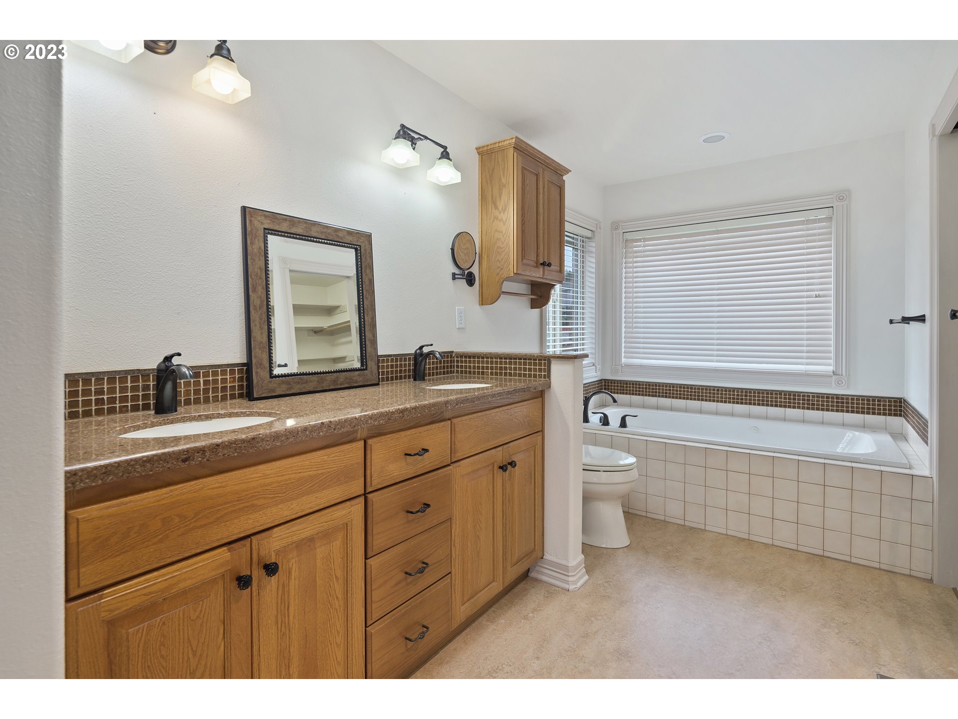1236 Southeast 26th Drive Gresham, OR 97080 - Photo 27 of 48 a bathroom with a granite countertop toilet a double vanity sink a mirror and a bathtub