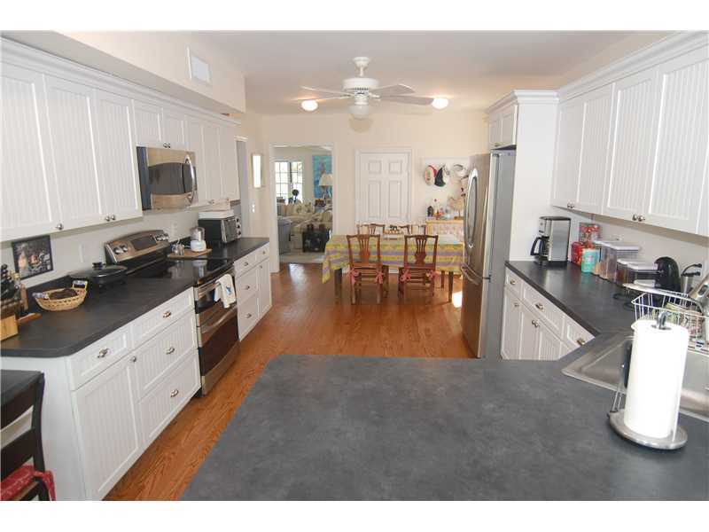 3 Yarmouth Road Rowayton, CT 06853 - Photo 9 of 15 a open kitchen with stainless steel appliances granite countertop a stove top oven a sink a dining table and chairs with white cabinets