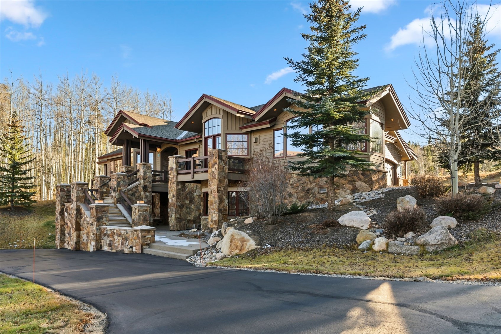2140 Hunter's Knob Road Silverthorne, CO 80498 - Photo 2 of 46 Chalet / cabin featuring stairway, stone siding, a balcony, board and batten siding, and asphalt driveway