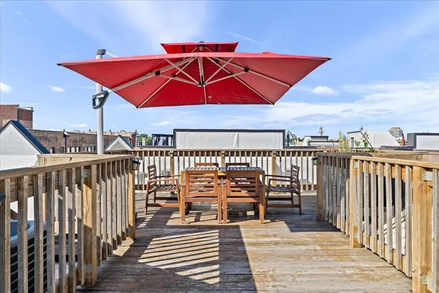 a roof deck with wooden floor and barbeque oven
