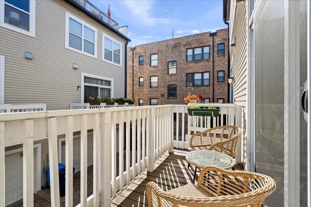 a balcony of a house with wooden floor stairs and furniture