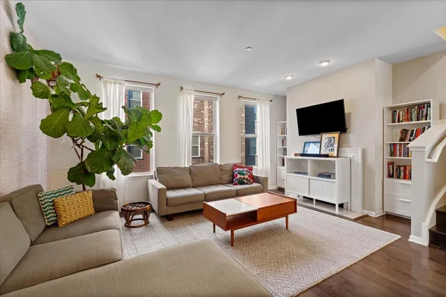 a living room with furniture potted plant and a flat screen tv