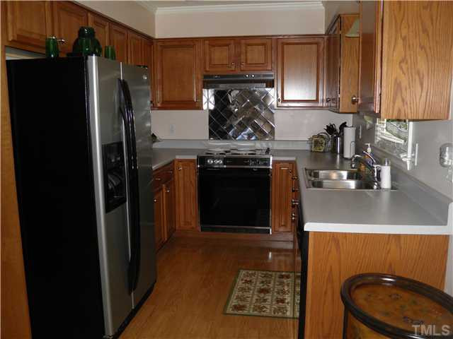2221 Cooper Branch Road Clayton, NC 27520 - Photo 14 of 15 Updated kitchen has lots of cabinets, stainless backsplash and hardwood flooring. Kitchen is open to the dining/ living area and next to the entrance to the sunroom.