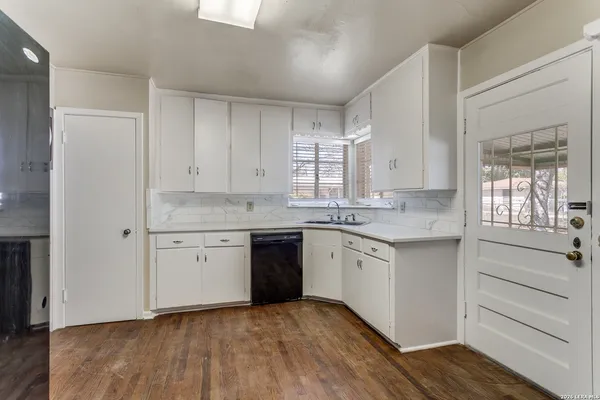 a kitchen with granite countertop white cabinets and white appliances