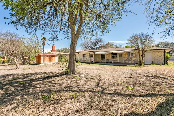 a front view of a house with a yard and trees
