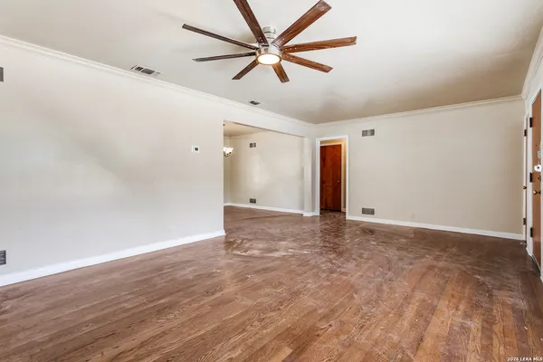 a view of empty room with wooden floor