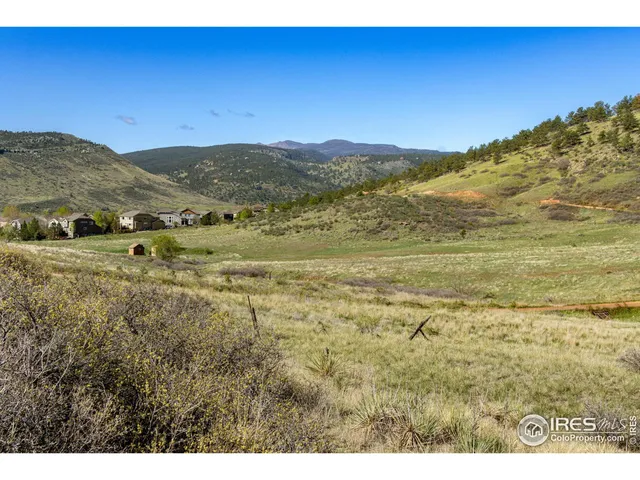 a view of a field with mountains in the background