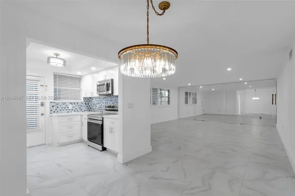 a kitchen with white cabinets and appliances
