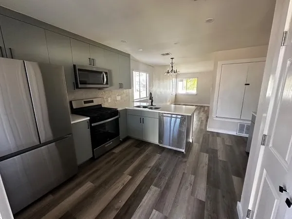 a kitchen with stainless steel appliances a refrigerator a sink a stove a microwave a sink and dishwasher