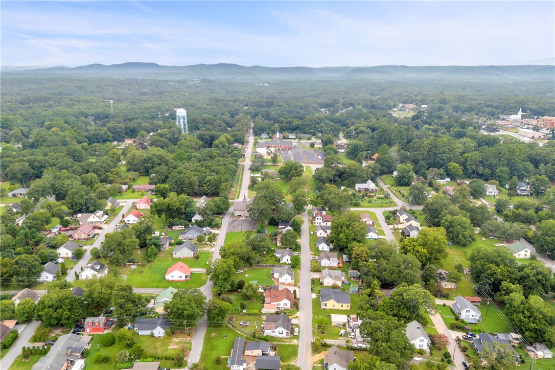 308 Verner Street Walhalla, SC 29691 - Photo 47 of 49 Aerial perspectives reveal a tranquil residential neighborhood bordered by rolling hills and dense woodlands.