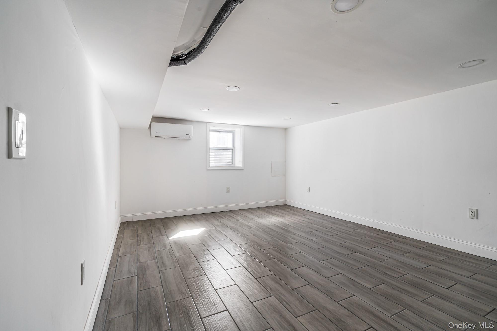 65 39th Street Islip, NY 11751 - Photo 22 of 30 an empty room with wooden floor and windows