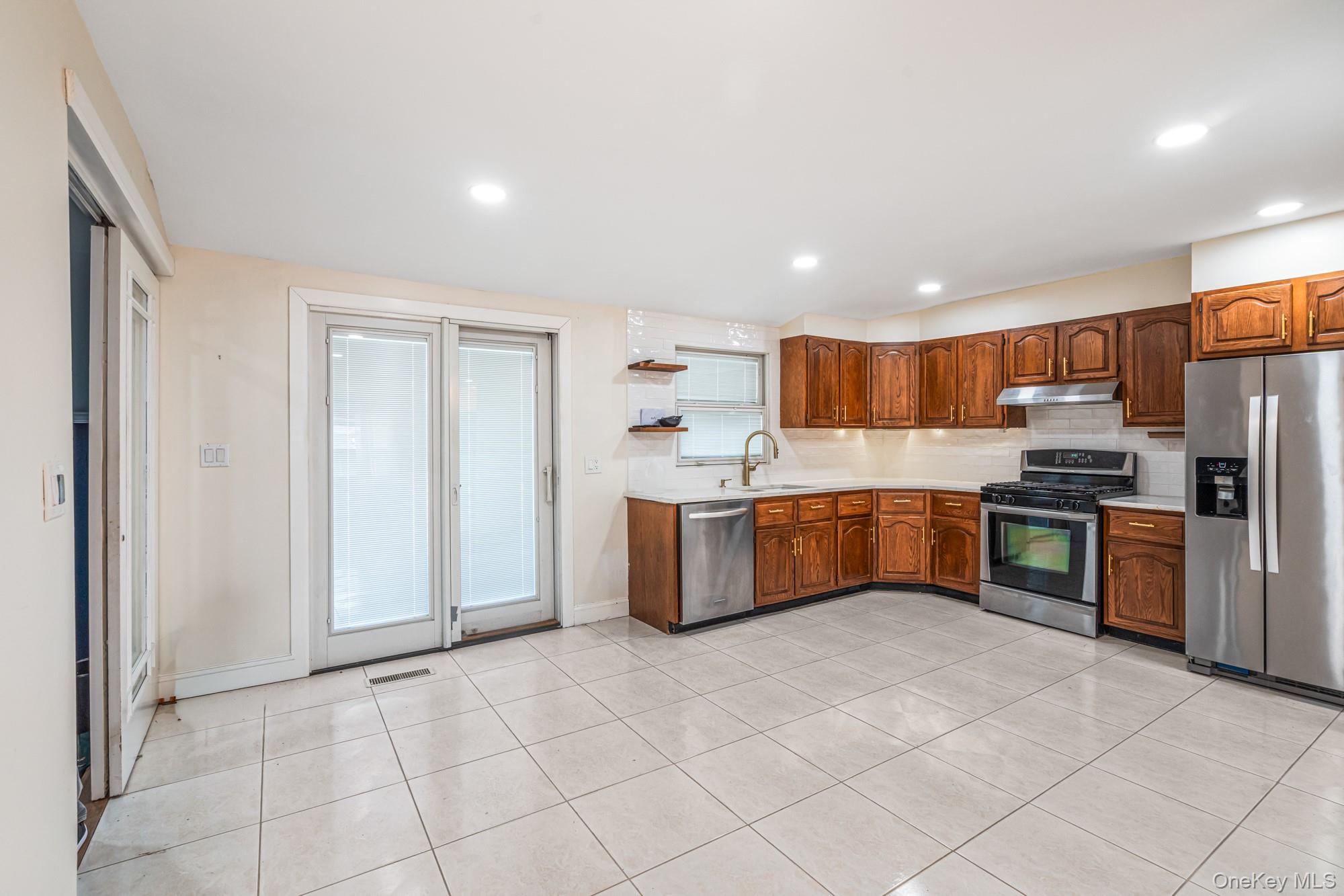 65 39th Street Islip, NY 11751 - Photo 6 of 30 a large kitchen with stainless steel appliances granite countertop a stove a sink dishwasher and a refrigerator