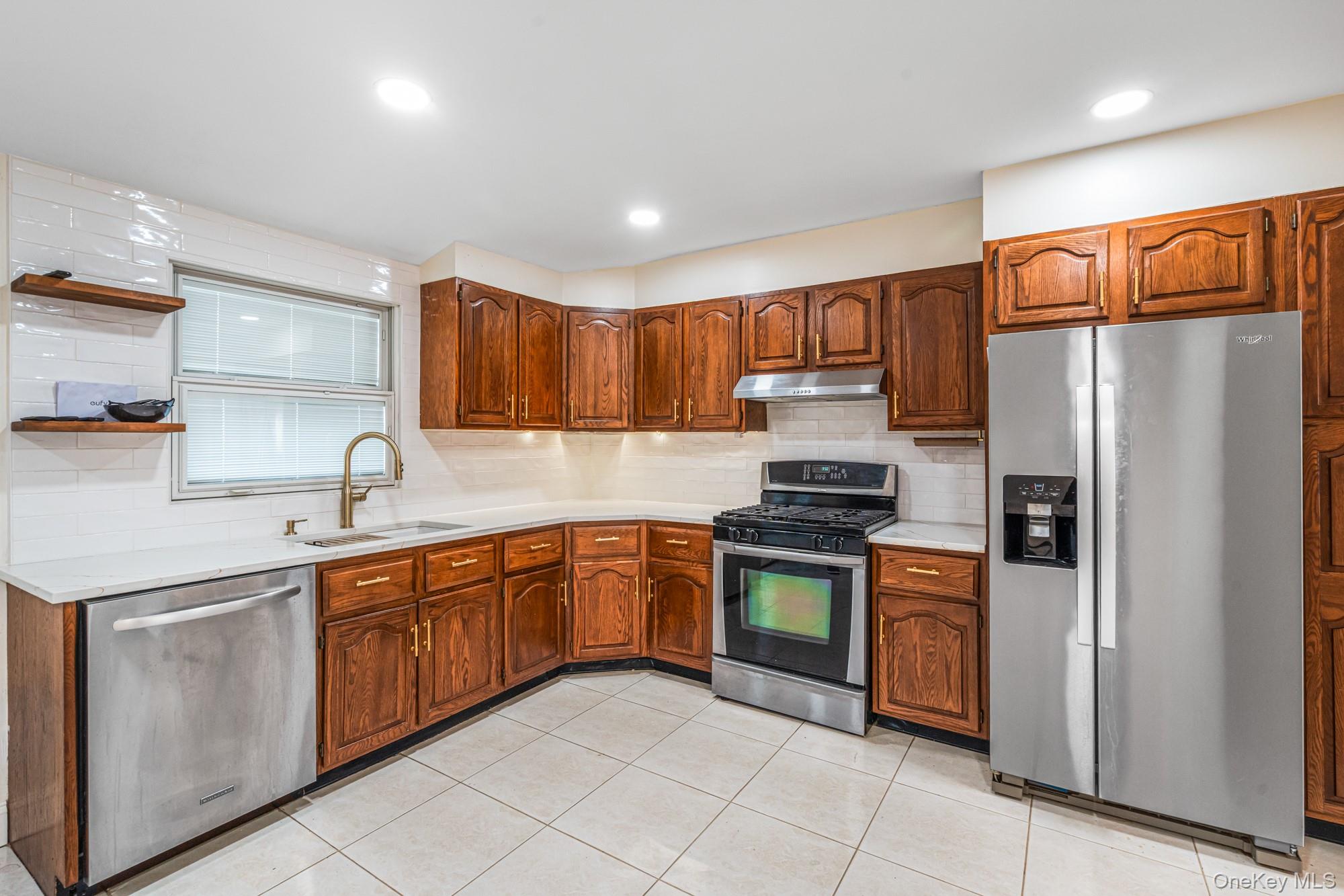 65 39th Street Islip, NY 11751 - Photo 7 of 30 a kitchen with stainless steel appliances granite countertop a refrigerator sink and cabinets
