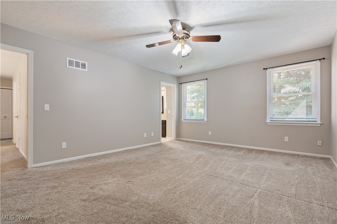 3960 Bramshaw Road Northwest Canton, OH 44718 - Photo 19 of 33 Empty room featuring light carpet, a textured ceiling, and ceiling fan