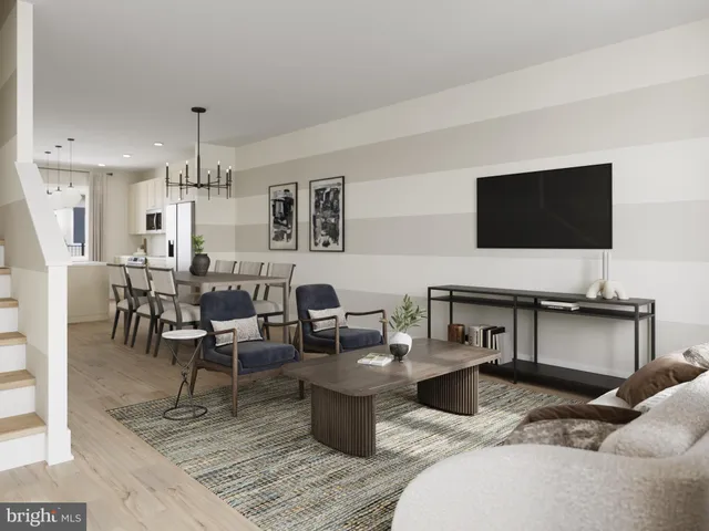 a living room with furniture a flat screen tv and kitchen view