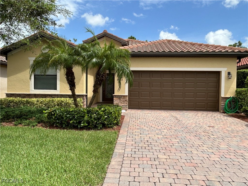 8963 Water Tupelo Road Fort Myers, FL 33912 - Photo 1 of 37 a front view of a house with a garden