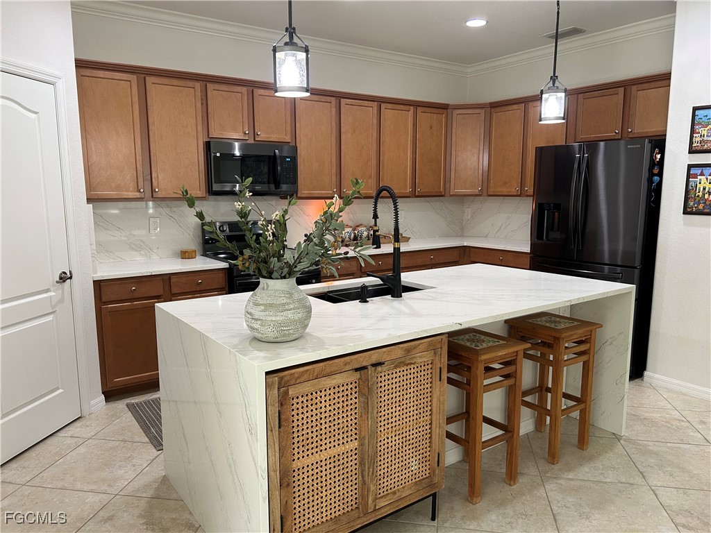 8963 Water Tupelo Road Fort Myers, FL 33912 - Photo 24 of 37 a kitchen with stainless steel appliances a sink a microwave a refrigerator and cabinets