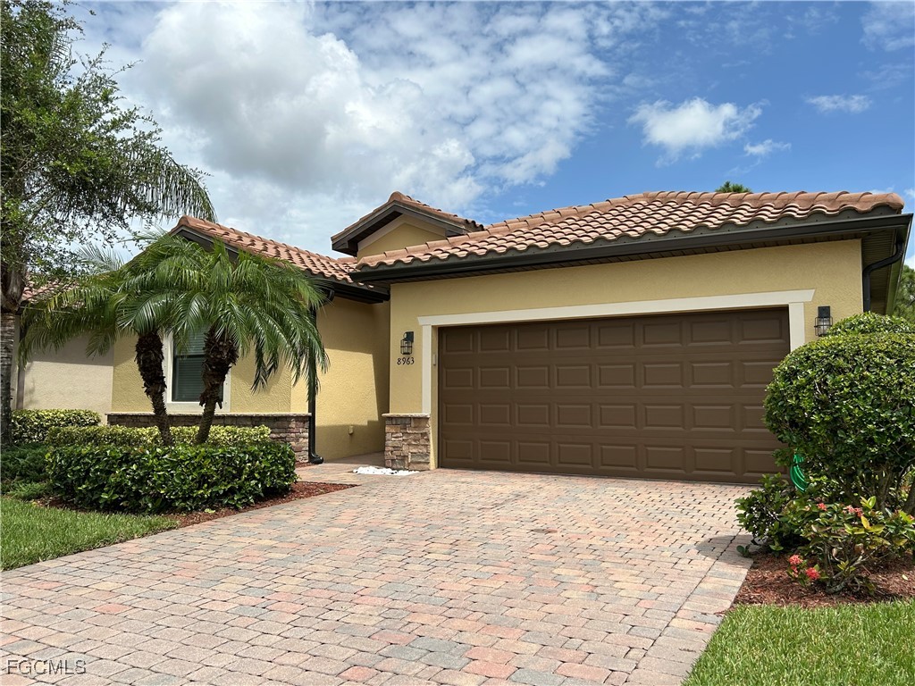 8963 Water Tupelo Road Fort Myers, FL 33912 - Photo 3 of 37 a front view of a house with a yard and garage