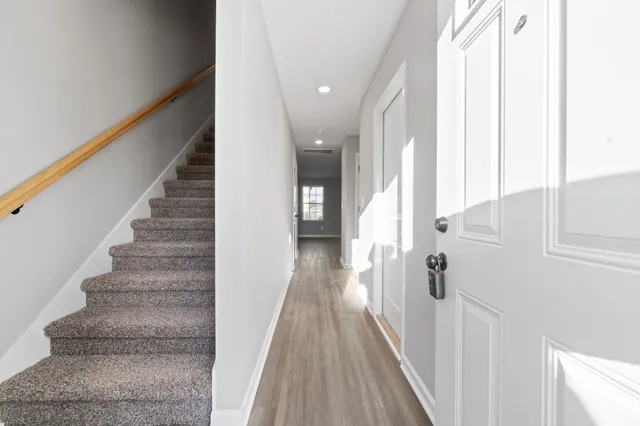 a view of a hallway with wooden floor and staircase
