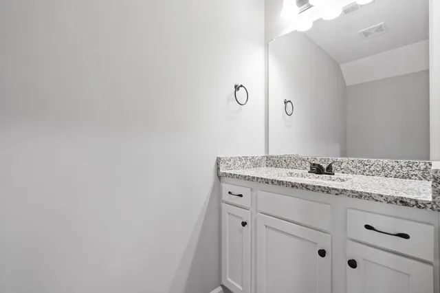 a bathroom with a granite countertop sink and mirror