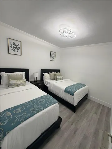 a bedroom with two beds and a chandelier