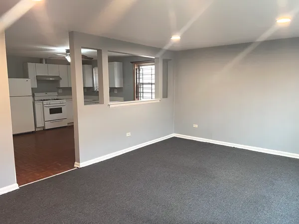 an empty room with a kitchen and a window