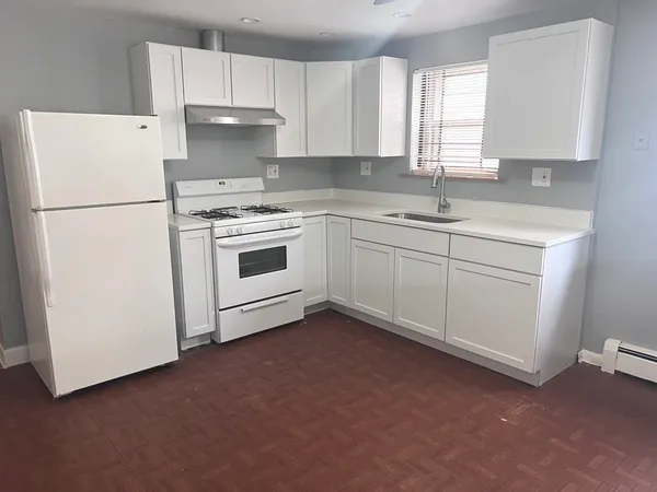 a kitchen with cabinets appliances a sink and a window