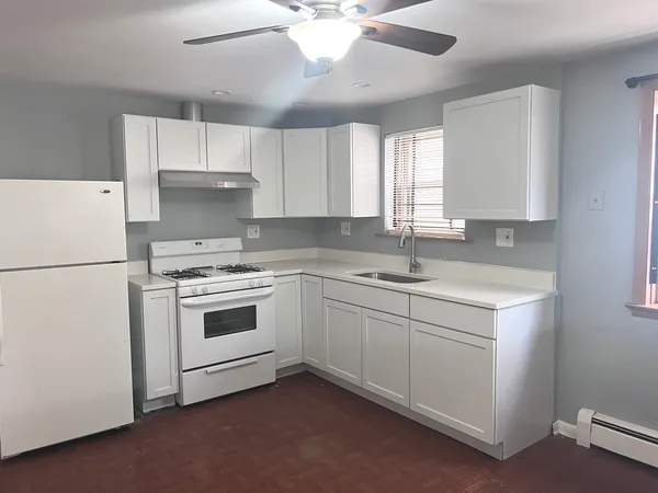 a kitchen with cabinets appliances a sink and a window