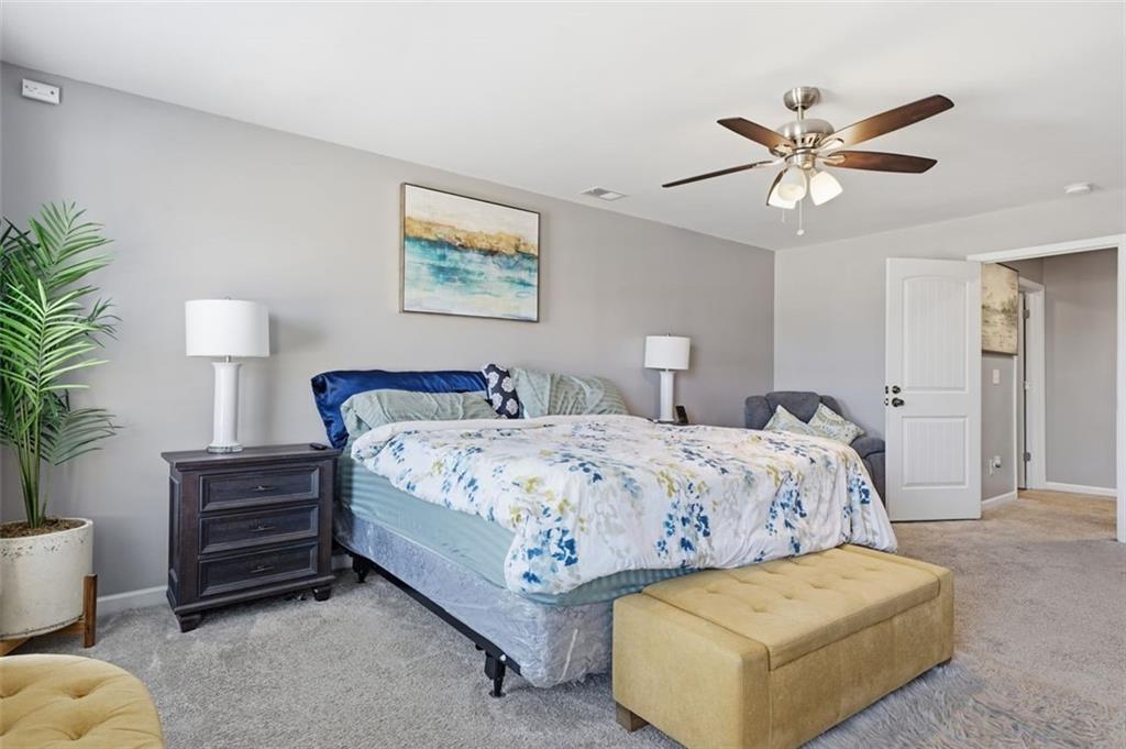 2234 Sawgrass Drive Hampton, GA 30228 - Photo 15 of 28 a bedroom with a bed and a chandelier