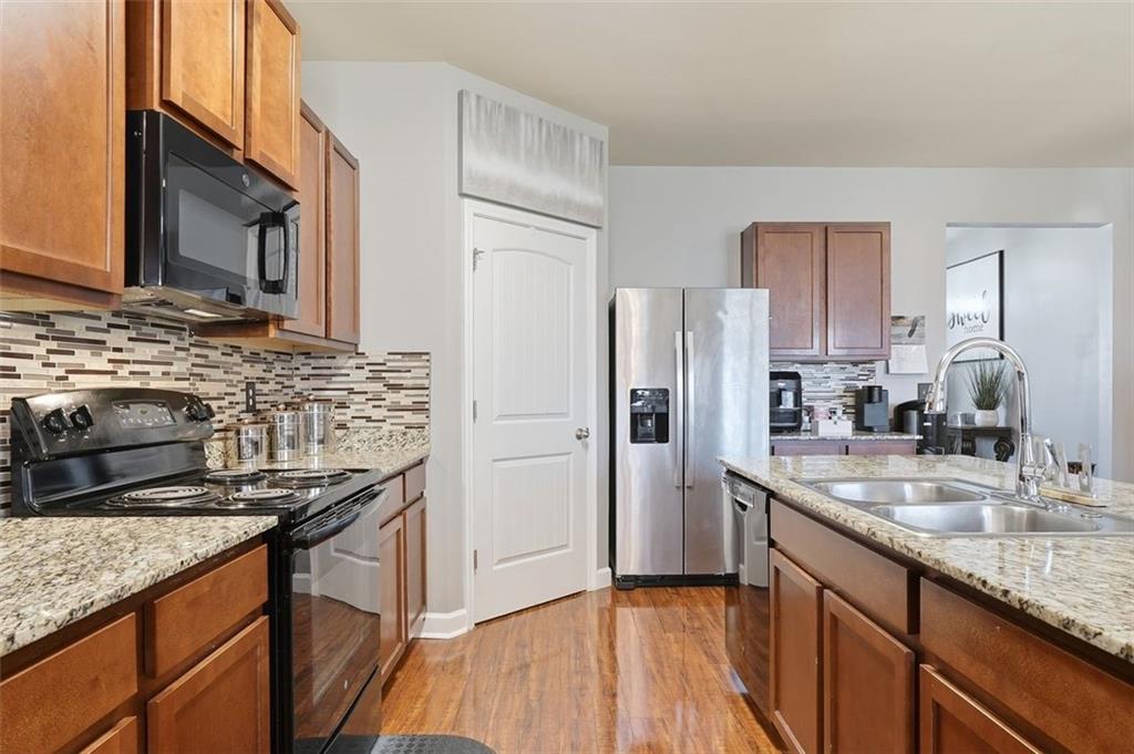 2234 Sawgrass Drive Hampton, GA 30228 - Photo 6 of 28 a kitchen with stainless steel appliances granite countertop a sink stove and refrigerator