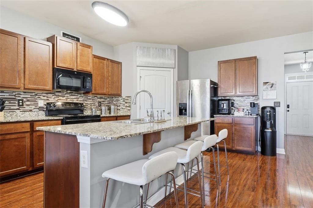 2234 Sawgrass Drive Hampton, GA 30228 - Photo 7 of 28 a kitchen with stainless steel appliances granite countertop a table chairs refrigerator a sink dishwasher and microwave