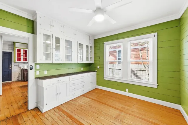 a view of an empty room with kitchen and a window
