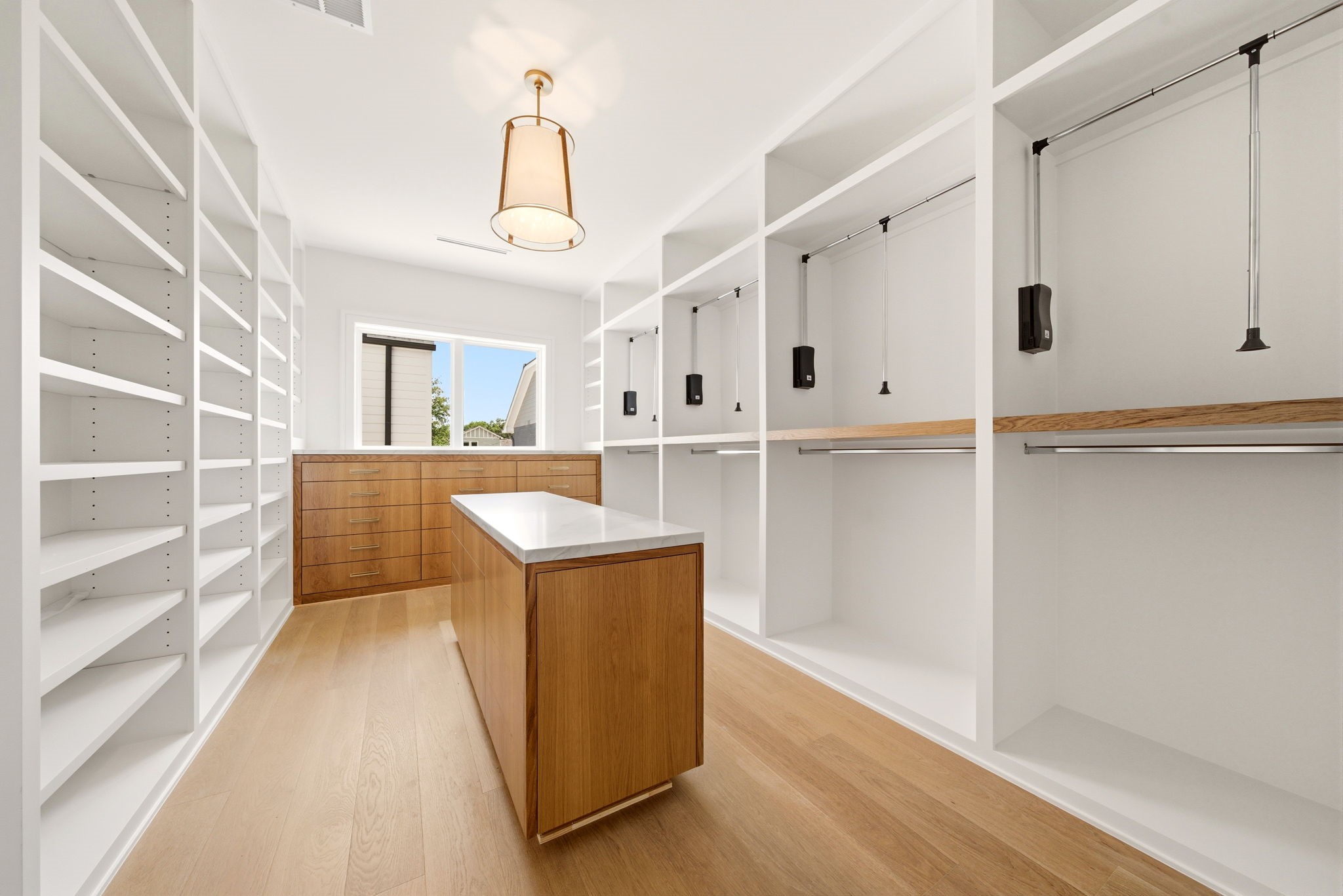 1023 Euclid Street Houston, TX 77009 - Photo 27 of 50 Boutique-style primary closet with center island, custom cabinetry, extensive shelving, and dedicated wardrobe storage.