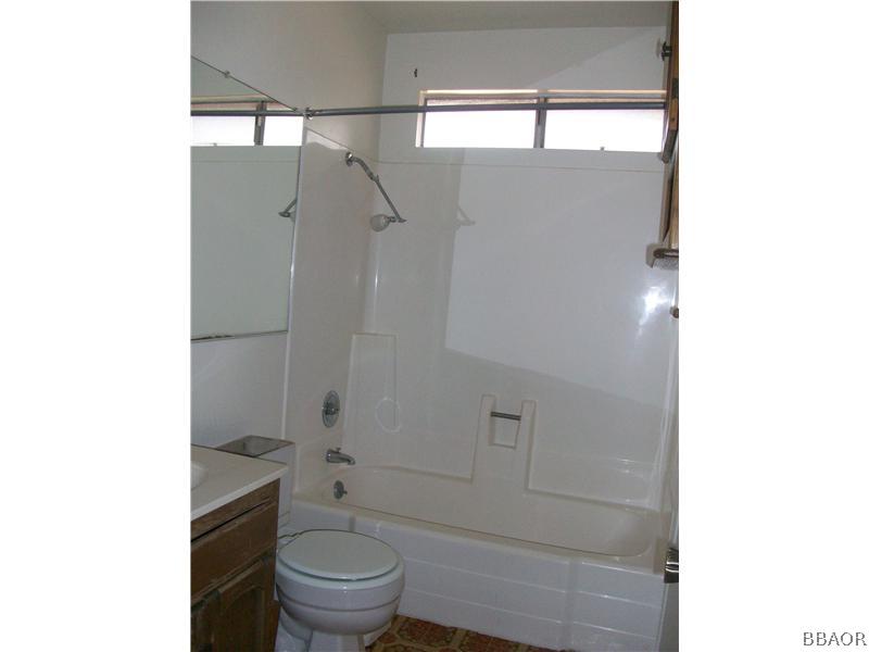 402 Riverside Sugarloaf, CA 92386 - Photo 8 of 18 a bathroom with a granite countertop toilet and a shower