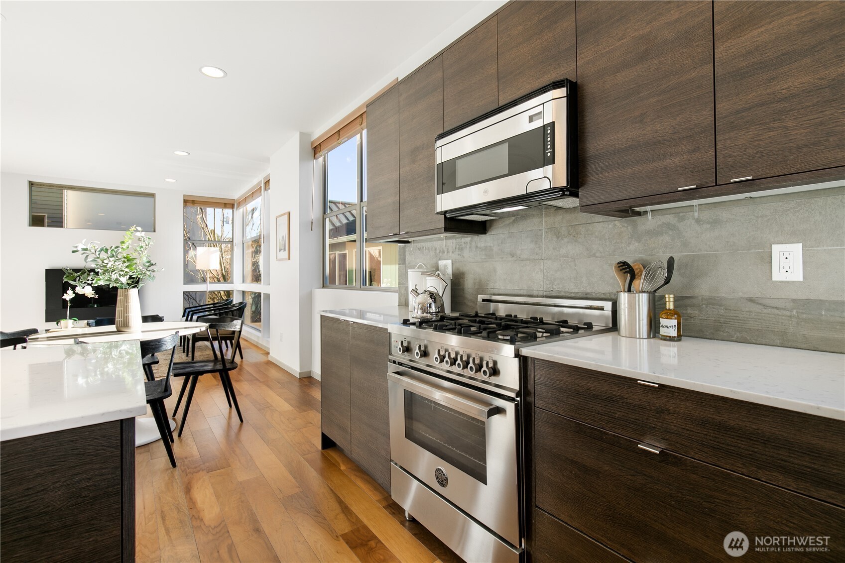 6729 14th Avenue Northwest, Unit B Seattle, WA 98117 - Photo 8 of 36 a kitchen with stainless steel appliances wooden floors and wooden cabinets