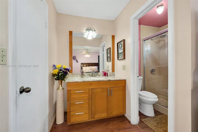 a spacious bathroom with a granite countertop sink a toilet and a mirror