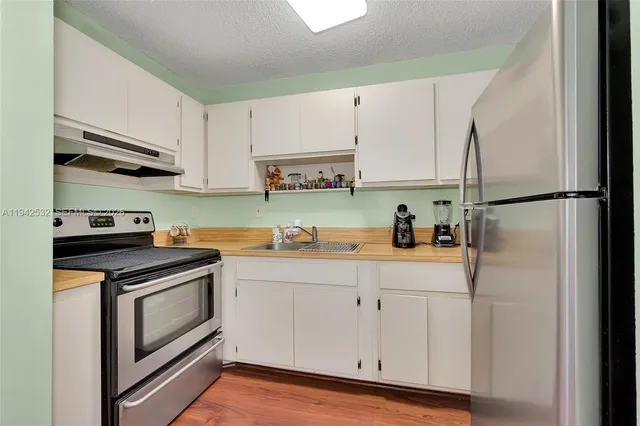 a kitchen with cabinets appliances and a sink