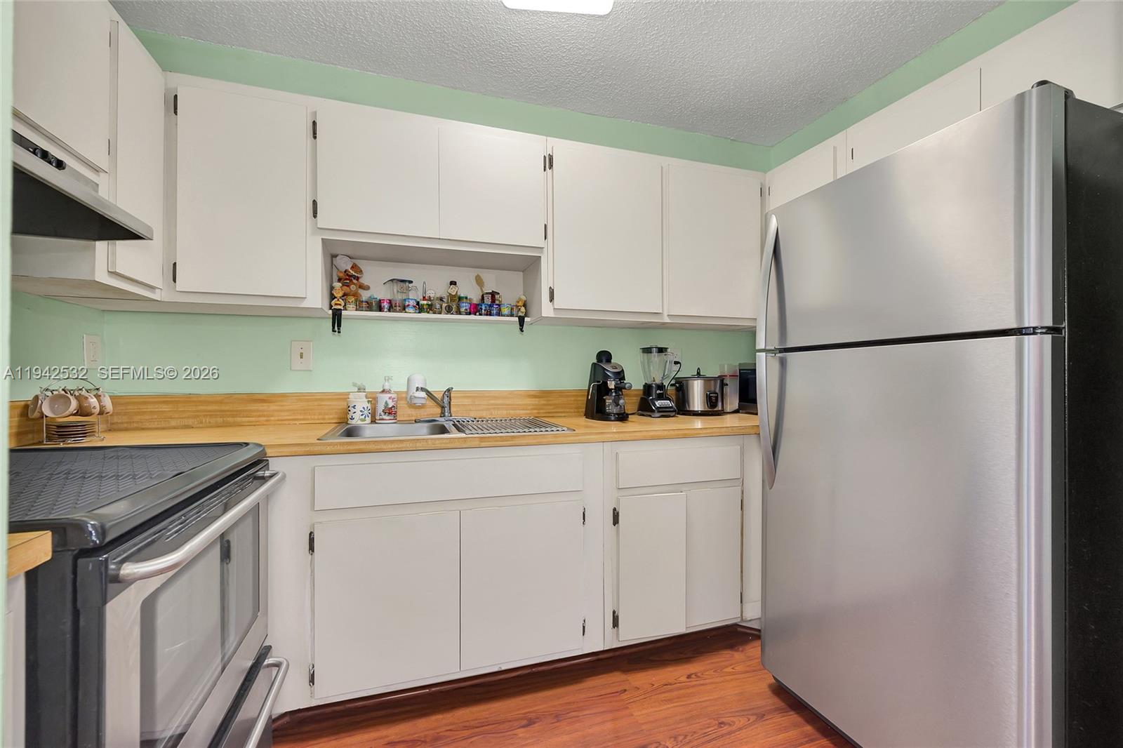 12960 Southwest 66th Lane, Unit 1081 Miami, FL 33183 - Photo 8 of 20 a kitchen with a sink a refrigerator and cabinets