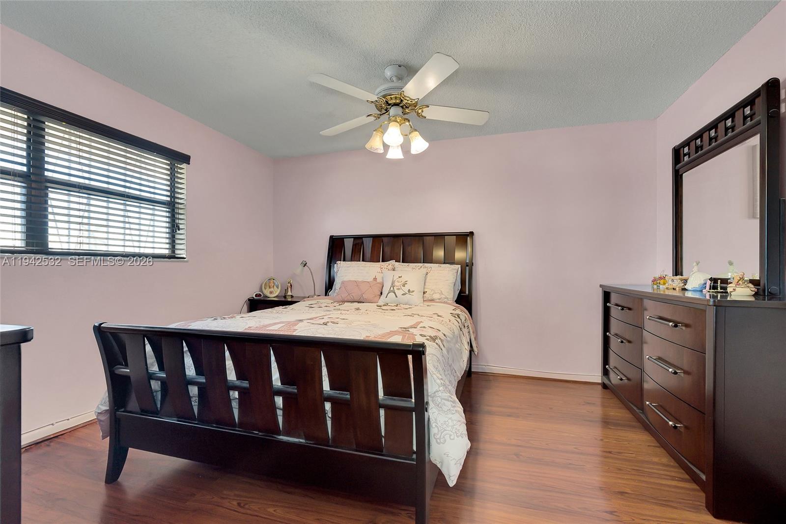 12960 Southwest 66th Lane, Unit 1081 Miami, FL 33183 - Photo 10 of 20 a bedroom with a bed and a chandelier
