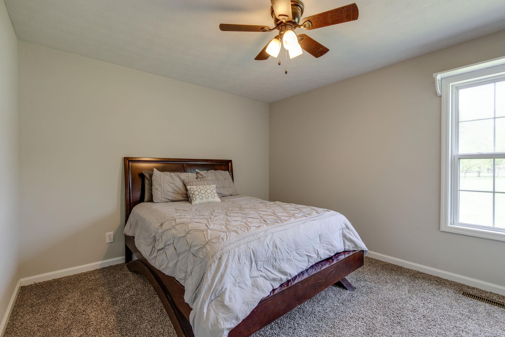 349 Lear Road Portland, TN 37148 - Photo 18 of 24 a bedroom with a bed and a chandelier