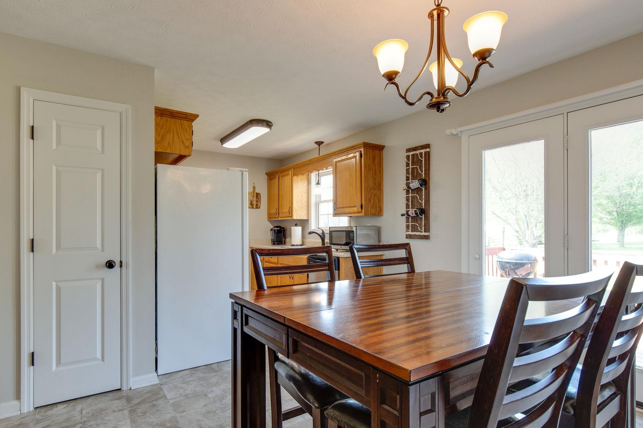 349 Lear Road Portland, TN 37148 - Photo 9 of 24 a dining room with wooden floor a chandelier a wooden table and chairs