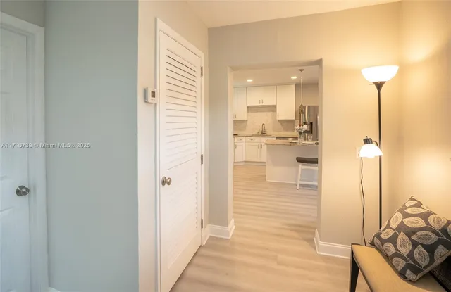a kitchen with stainless steel appliances granite countertop a table chairs and a refrigerator