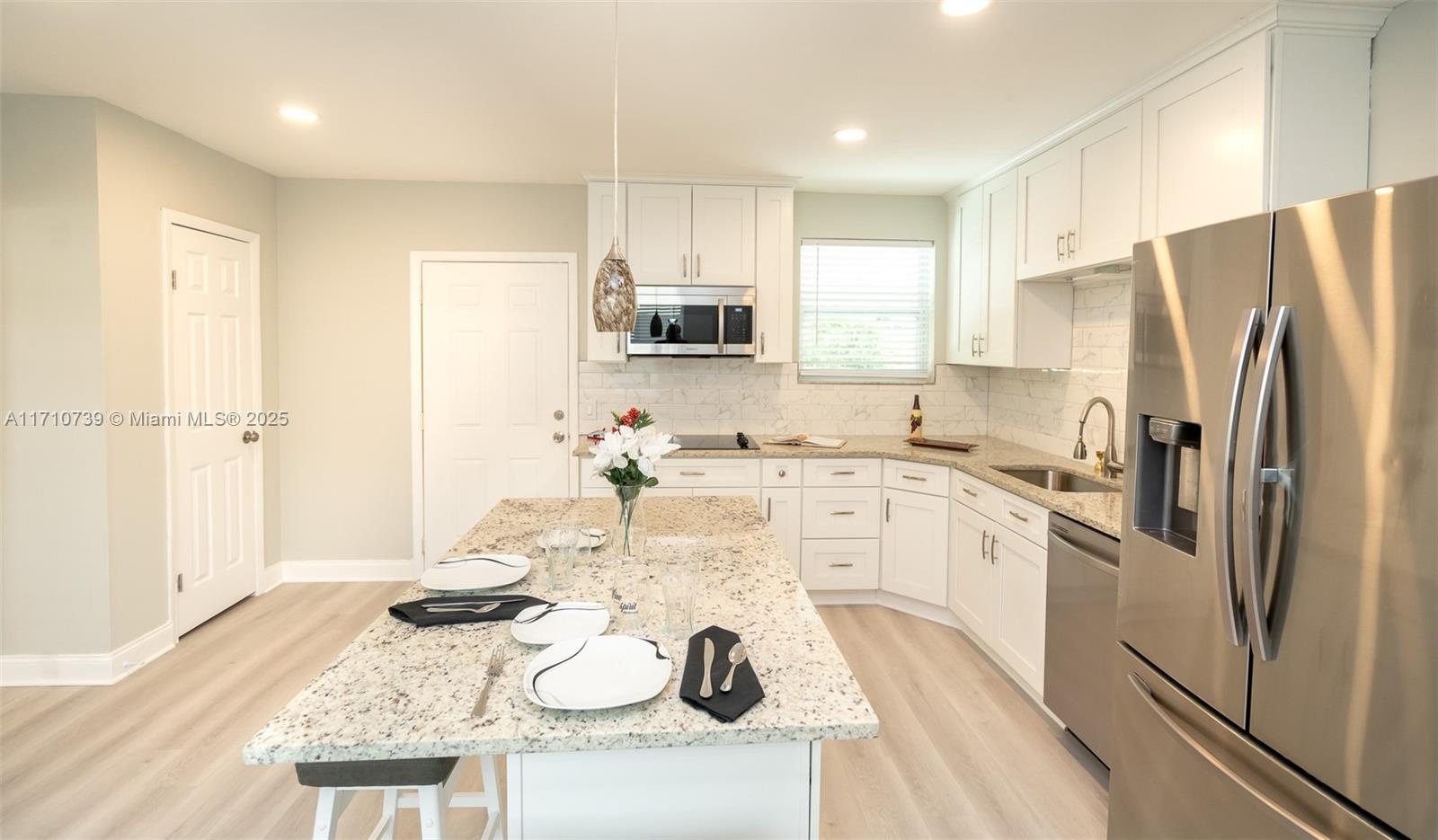 2230 Southwest 60th Court Miami, FL 33155 - Photo 23 of 64 a kitchen with stainless steel appliances kitchen island granite countertop a refrigerator and a stove top oven