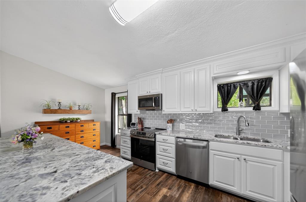23363 Wateridge Loop Flint, TX 75762 - Photo 23 of 40 a kitchen with stainless steel appliances granite countertop a sink stove and refrigerator