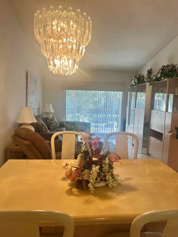 a kitchen with a table chairs and chandelier