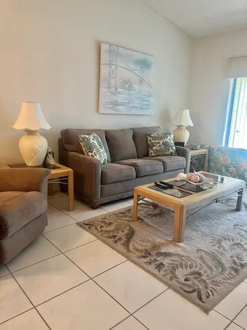 a living room with furniture a lamp and a rug