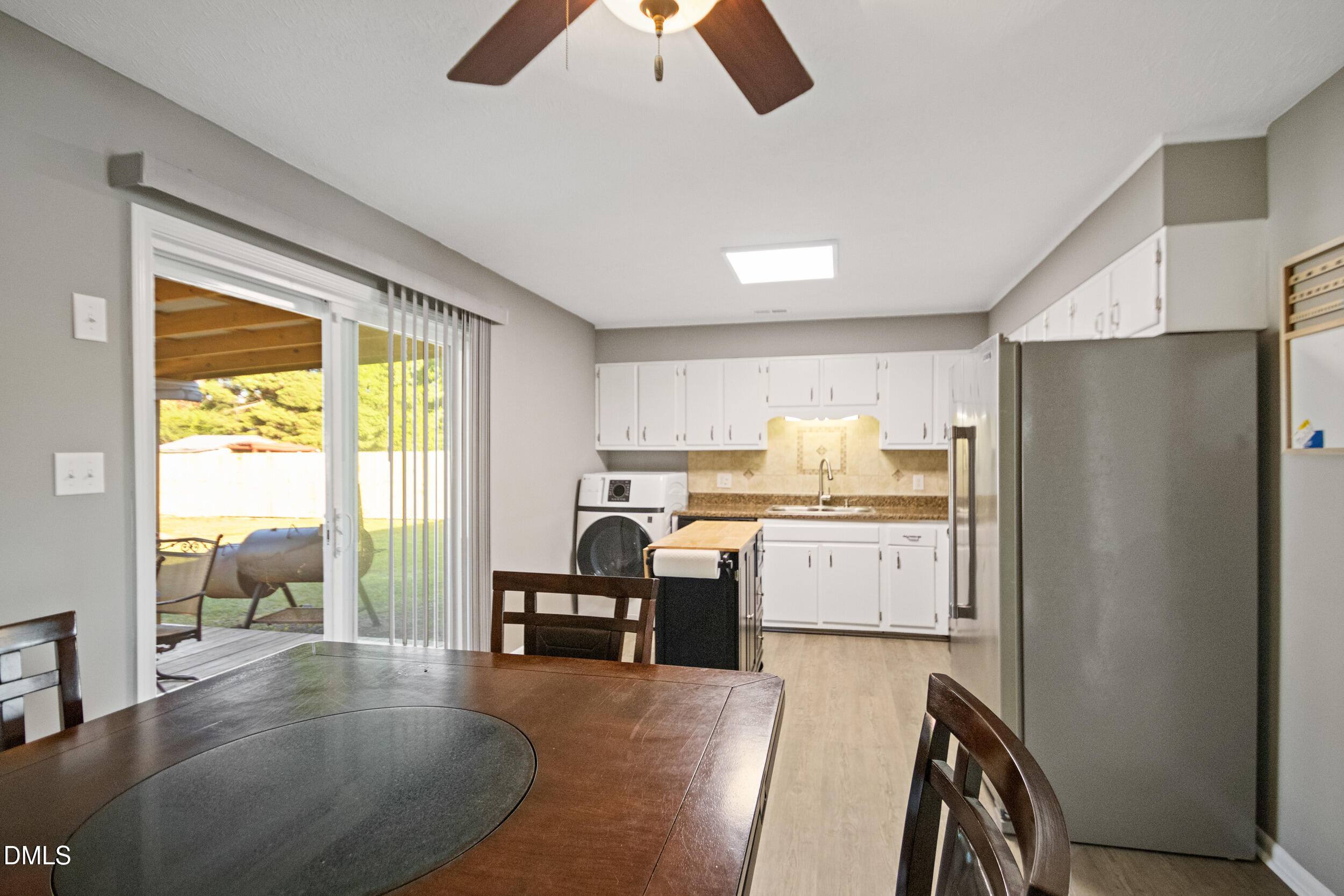5909 Spinner Road Hope Mills, NC 28348 - Photo 11 of 24 a kitchen with a table chairs refrigerator and cabinets